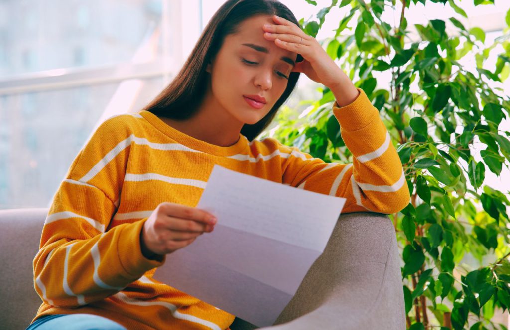 Lady in yellow sweater reading a letter