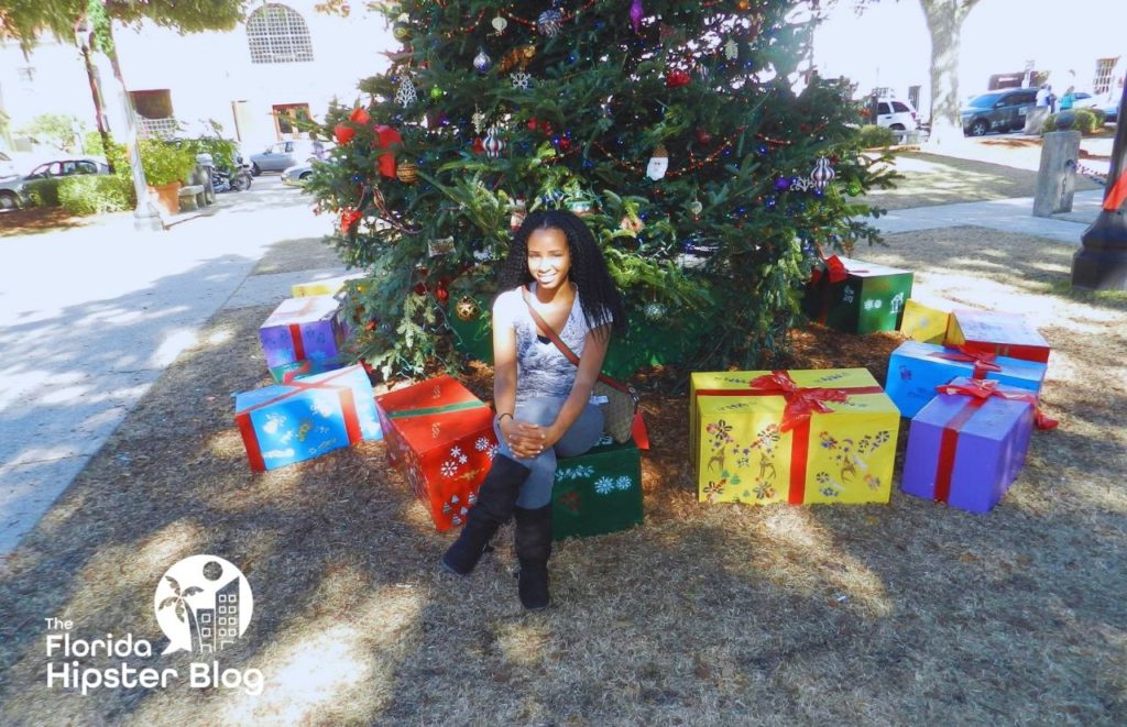 NikkyJ in front on Christmas tree in St Augustine Florida. Keep reading to learn how to budget for the holidays and for Christmas.