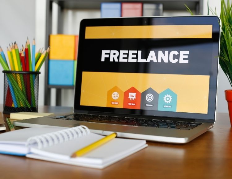 Freelance title on laptop with notepad and pencil